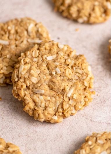 Freshly baked soft oatmeal cookies stacked on a plate with a chewy texture and golden brown edges.
