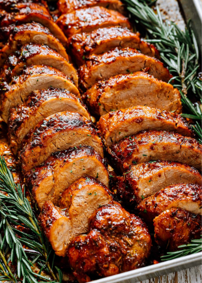 Juicy oven-roasted pork tenderloin seasoned with paprika, garlic, rosemary, and herbs, sliced and served on a plate.