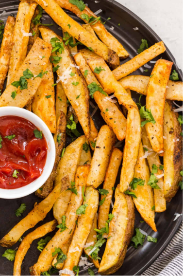 Golden, crispy homemade French Fries Recipe cooked in an air fryer and served with ketchup.
