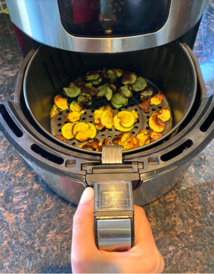 air fryer zucchini chips Golden, crispy air fryer zucchini chips served on a plate with a creamy dipping sauce.