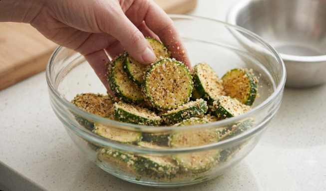 air fryer zucchini chips Golden, crispy air fryer zucchini chips served on a plate with a creamy dipping sauce.